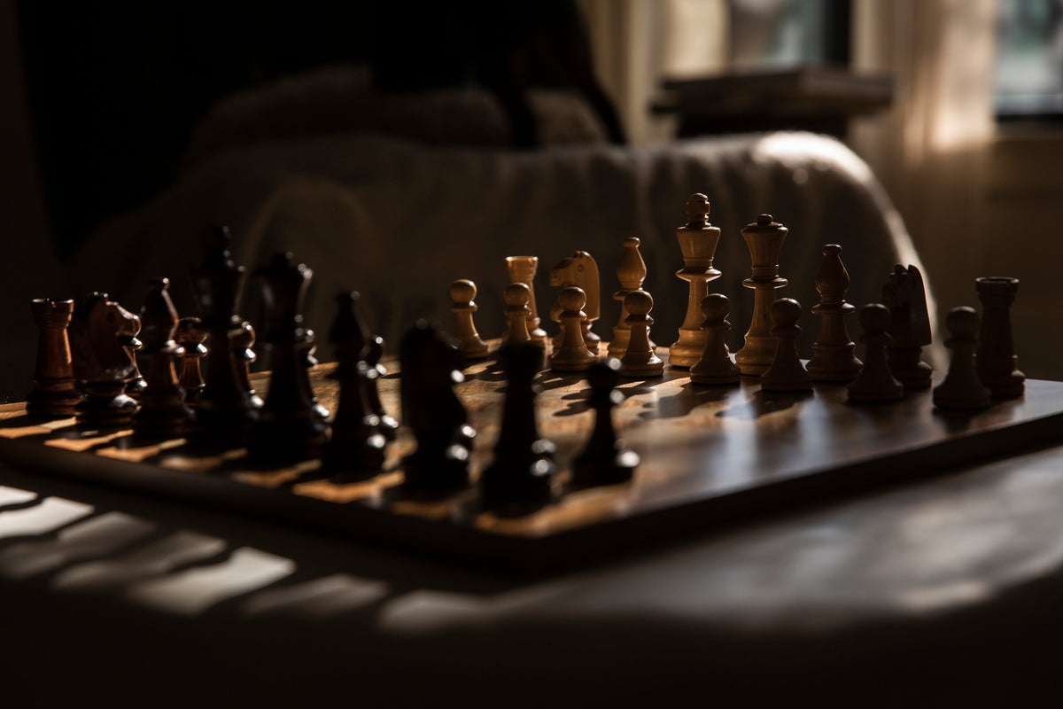 Jeu d'échecs en bois dans la lumière d'une fenêtre